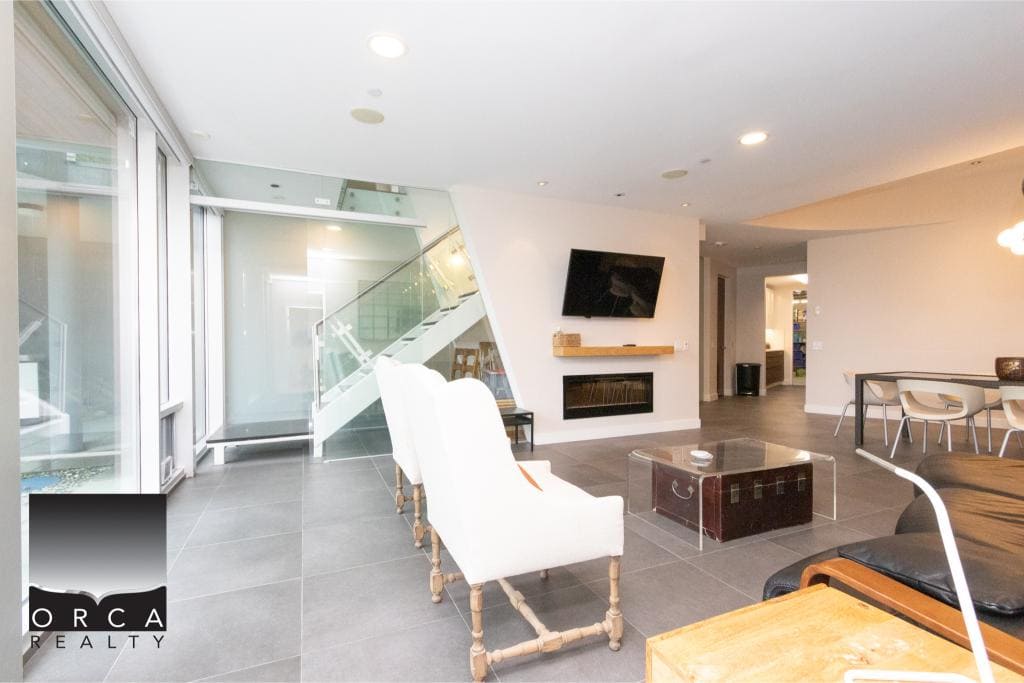 Spacious and stylish living room interior at Ansell Place, featuring contemporary furniture, a wall-mounted TV, and large windows that provide natural light, perfect for comfortable urban living.