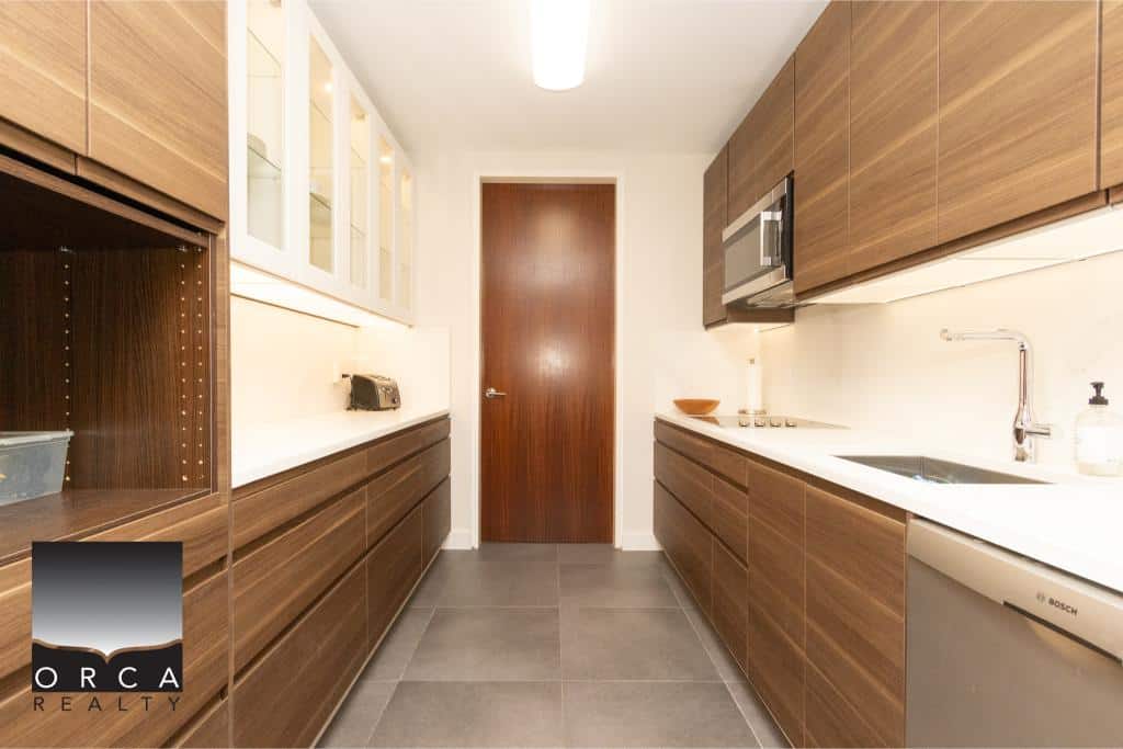 Spacious and contemporary kitchen featuring sleek wooden cabinetry, stainless steel appliances, and ample storage, perfect for modern living in Ansell Place.