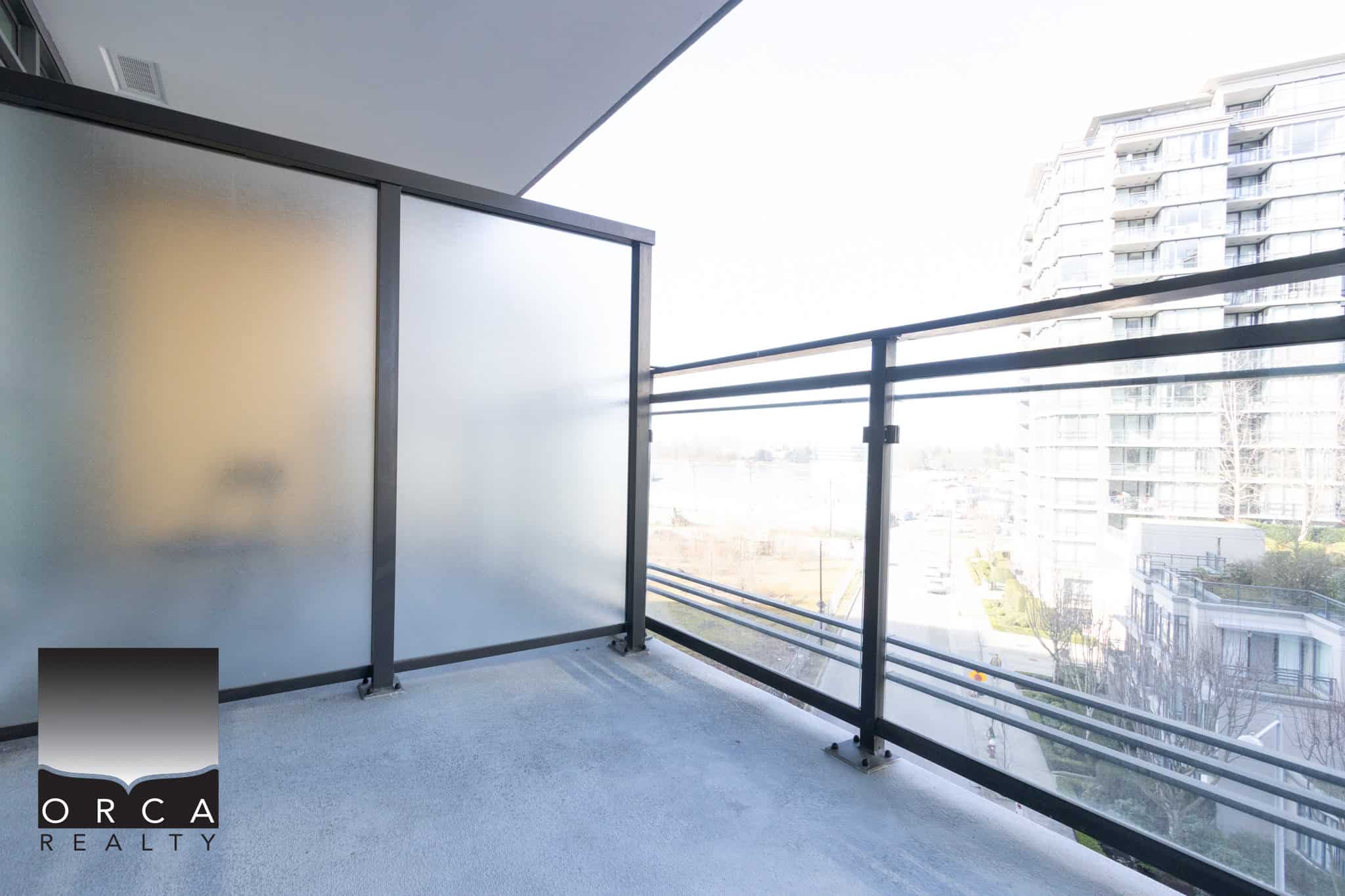 Modern Richmond Balcony with City Views Balcony with glass railing overlooking Richmond cityscape, ideal for outdoor relaxation and enjoying urban scenery.