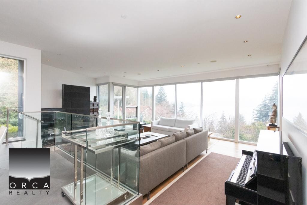 Spacious living room featuring large windows offering panoramic views, contemporary furniture, and natural light, perfect for relaxing or entertaining in a stylish home at Ansell Place.