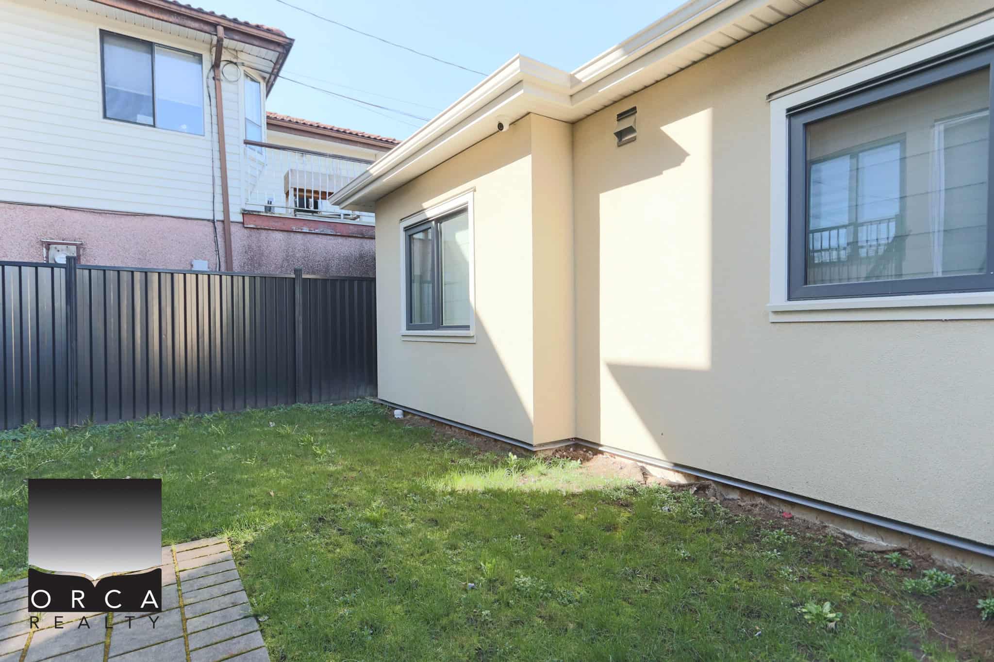 Bright, single-story Vancouver home with a small backyard, beige exterior walls, and large windows, located at 3-3545 East 26th Avenue, ideal for family living.