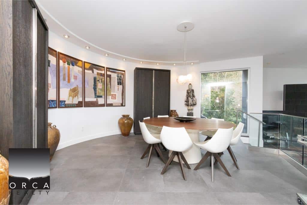 Spacious dining area featuring contemporary artwork, large windows, and stylish furniture, perfect for family gatherings or entertaining guests at Ansell Place.