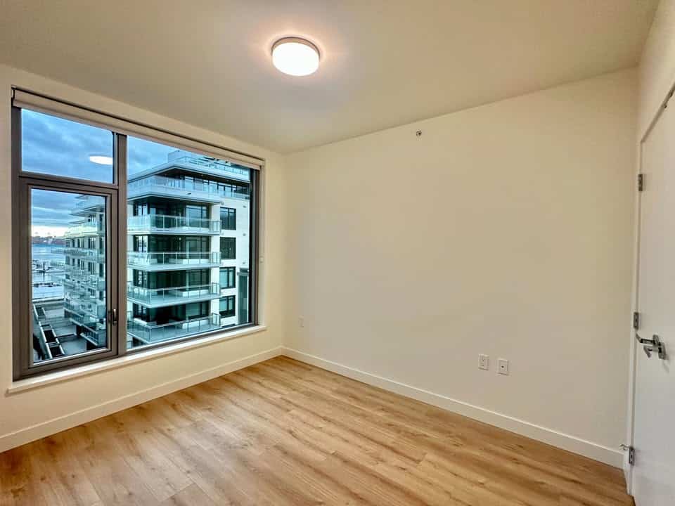 North Vancouver condo with large window and cityscape view.