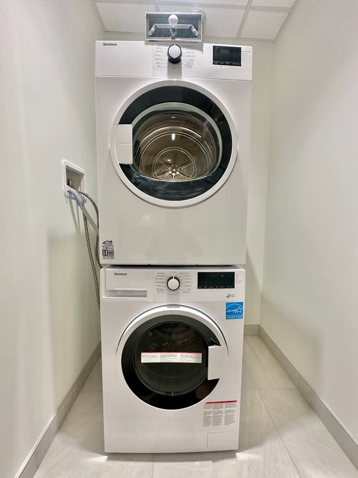 Stacked front-loading washing machine and dryer in a compact laundry space.