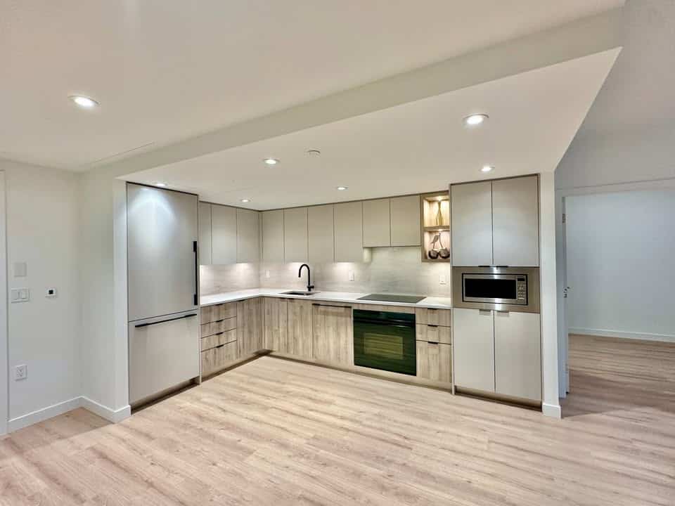 Modern North Vancouver kitchen featuring sleek stainless steel appliances, light wood cabinetry, and bright, open space perfect for contemporary living.