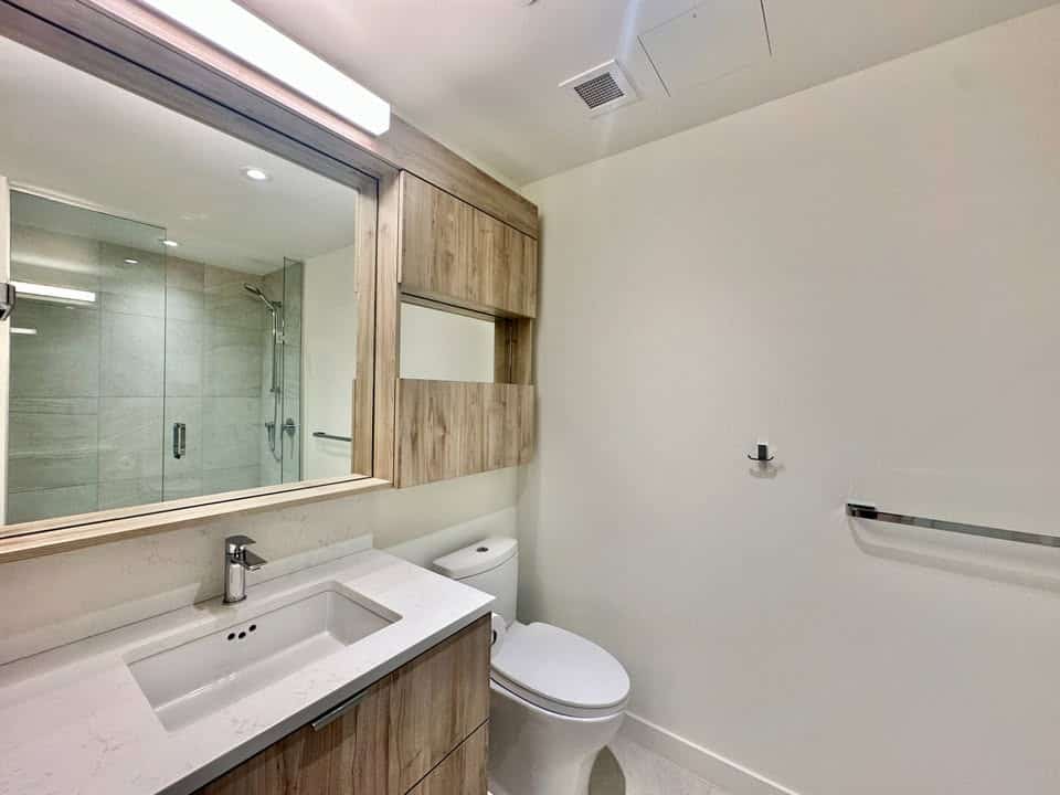 Bright and clean bathroom featuring a walk-in shower, contemporary fixtures, and natural light, located at 501-755 Harbourside Drive, North Vancouver.