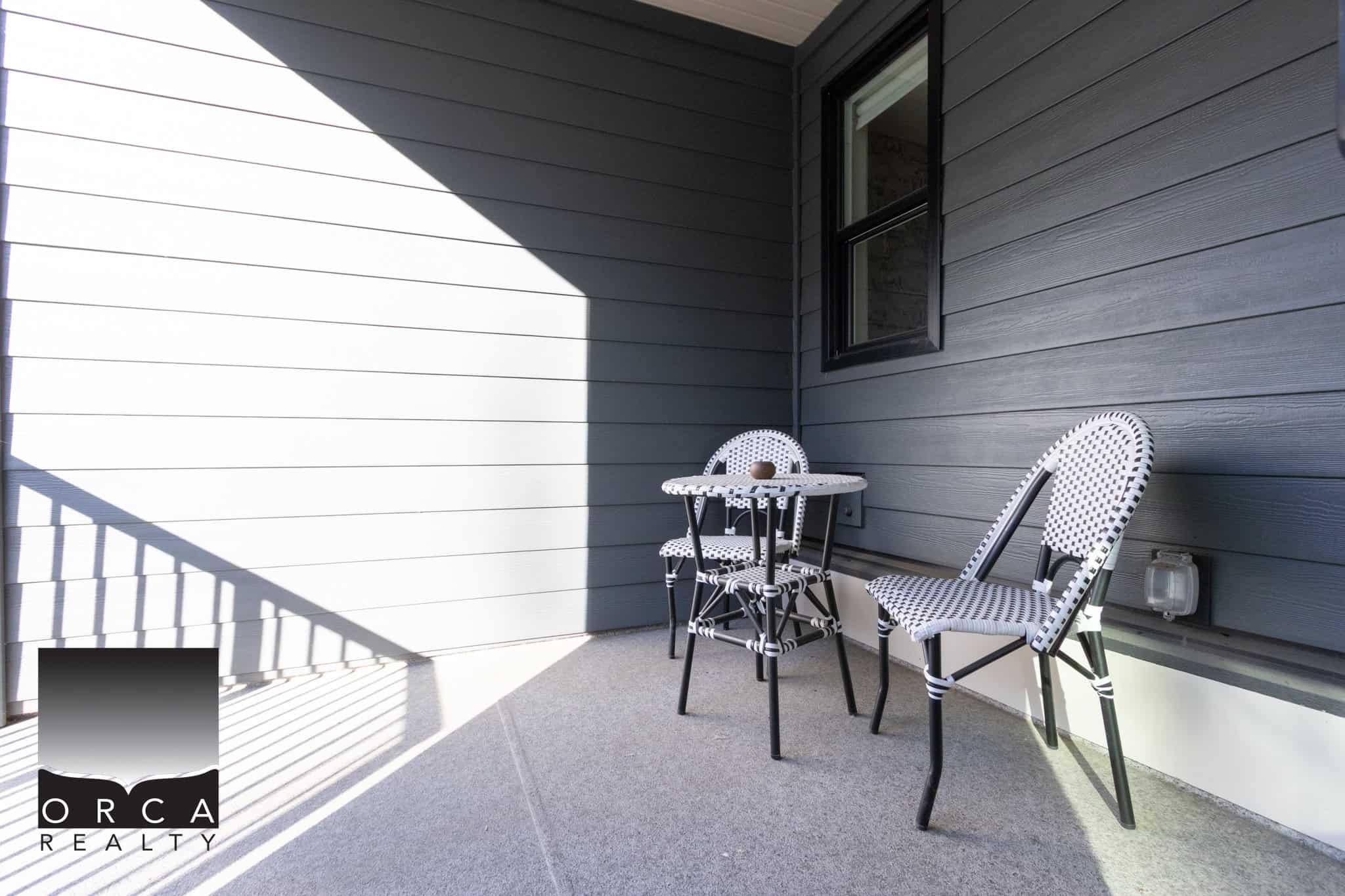 Bright outdoor balcony featuring a small table and two chairs, perfect for relaxing or enjoying a meal. Located at 25-19918 75A Avenue, Langley, offering a peaceful outdoor space.