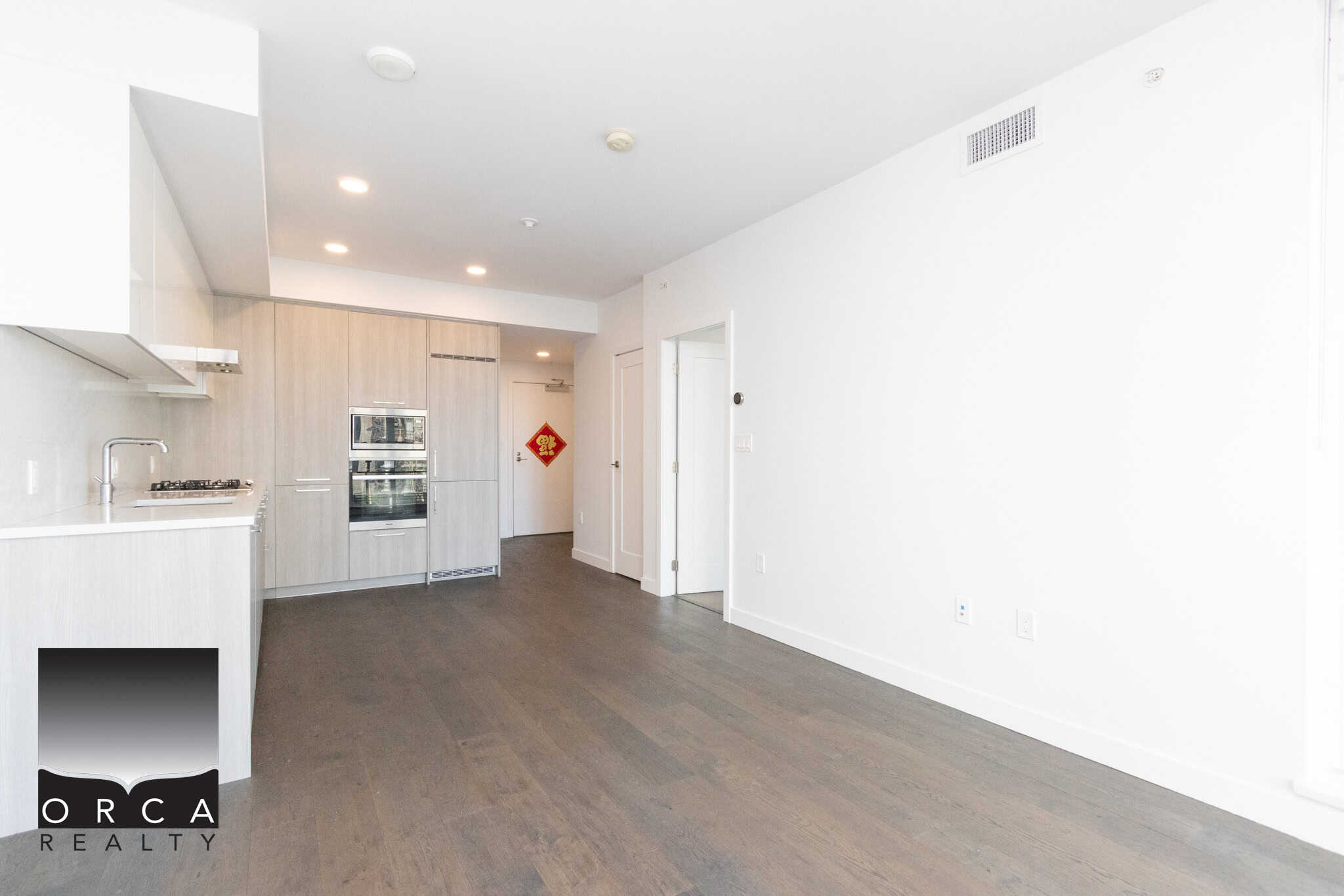 Modern Richmond Condo Interior with Open Floor Plan Bright and spacious living area in a Richmond condo, featuring sleek white walls, hardwood flooring, and contemporary kitchen design, perfect for comfortable urban living.