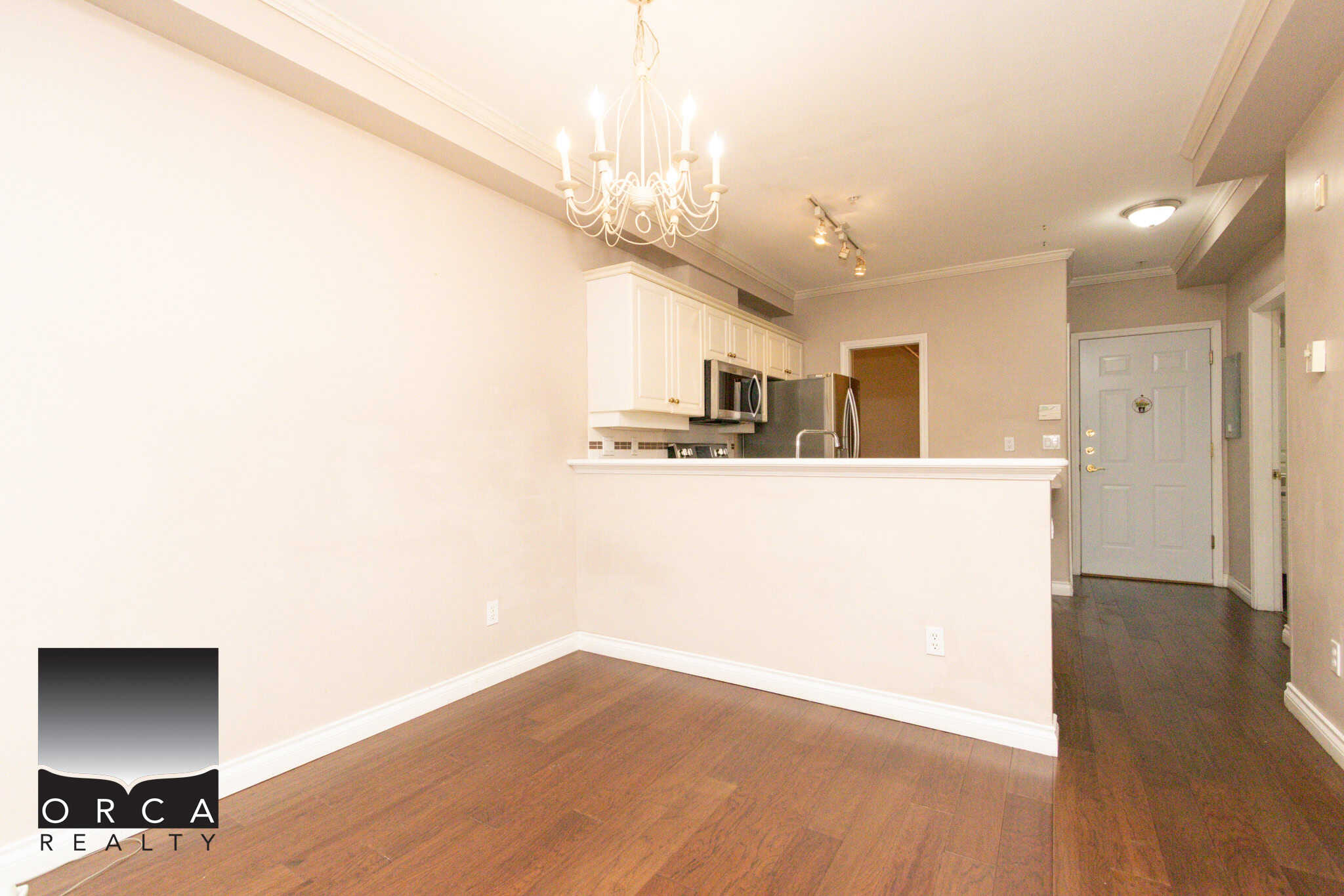 Spacious living area in a Coquitlam condo at 202-1185 Pacific St, featuring open-plan design, hardwood floors, and bright lighting, ideal for comfortable urban living.