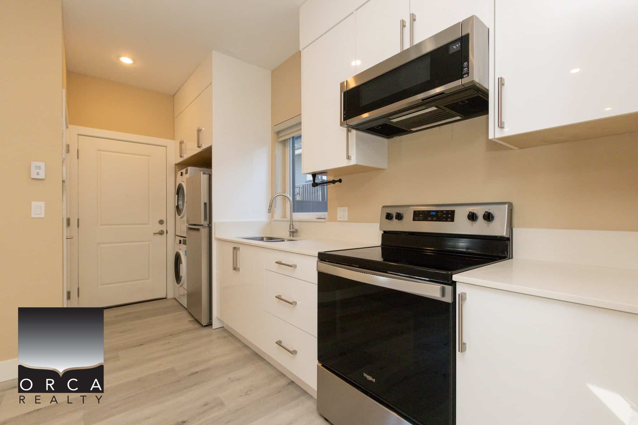 Bright and clean kitchen featuring white cabinetry, stainless steel appliances, and a functional layout in Vancouver. Perfect for contemporary living and homebuyers seeking stylish, efficient spaces.