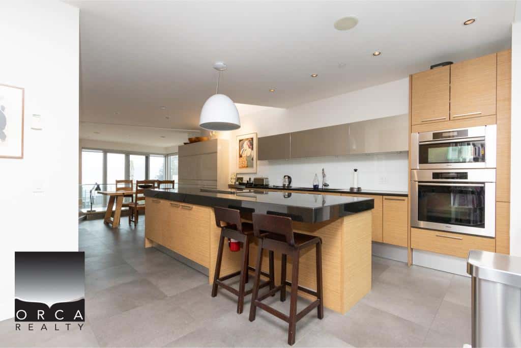 Spacious, contemporary kitchen featuring a sleek island, modern appliances, and ample natural light, perfect for comfortable living at Ansell Place.