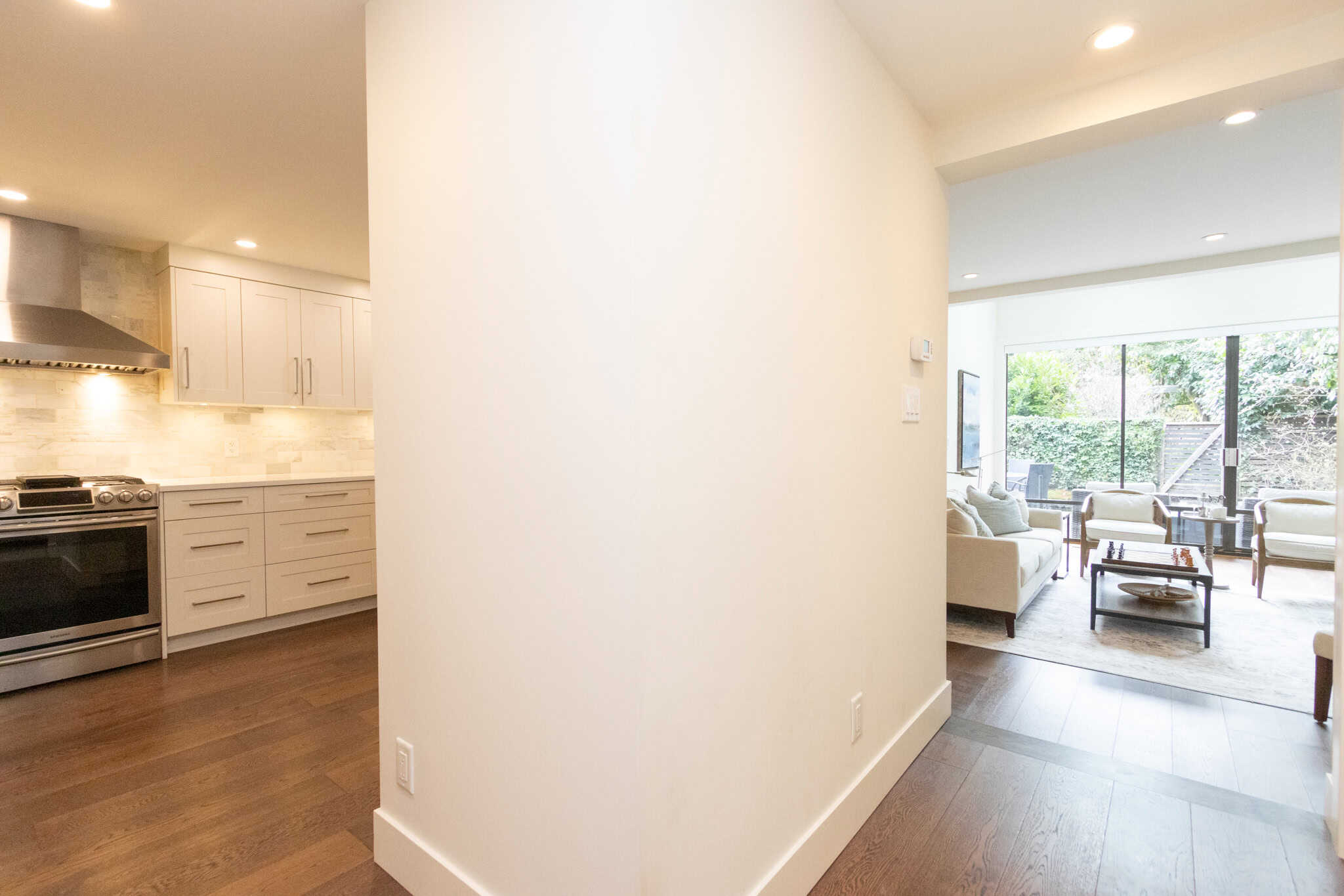 Modern West Vancouver home interior with open-concept living and kitchen area. Spacious living room with large windows, natural light, and contemporary decor in West Vancouver.