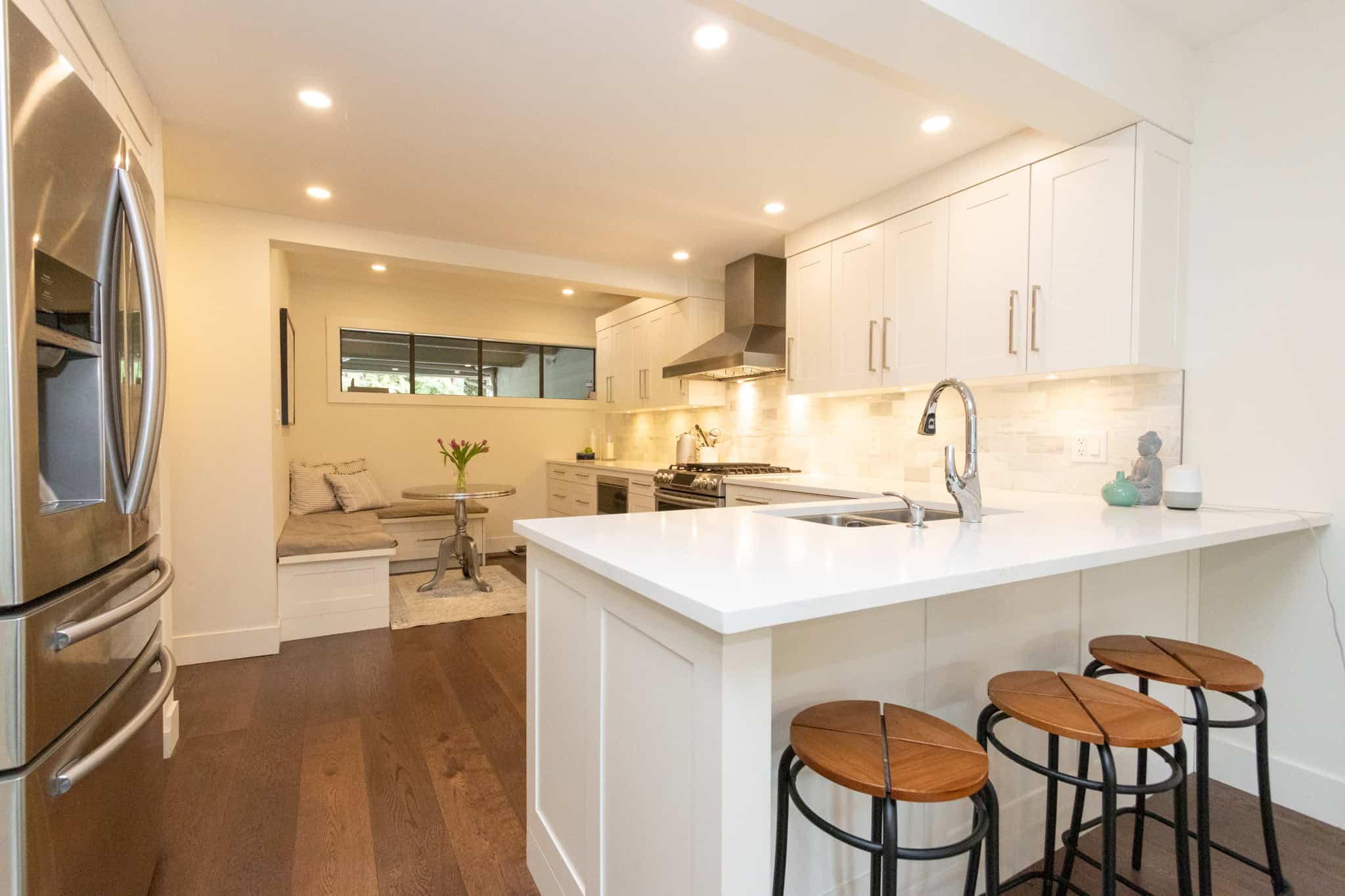 Modern West Vancouver Kitchen with Island Spacious kitchen featuring white cabinetry, stainless steel appliances, and a central island with seating, perfect for family gatherings and entertaining.