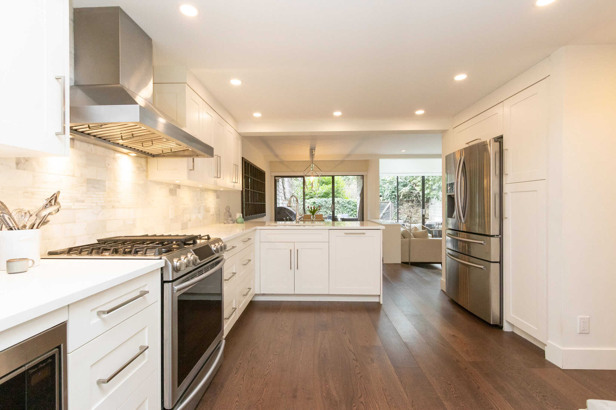 Modern West Vancouver Kitchen with Ocean Views Bright and spacious kitchen in West Vancouver featuring white cabinetry, stainless steel appliances, and large windows overlooking the ocean. Perfect for luxury living and entertaining.
