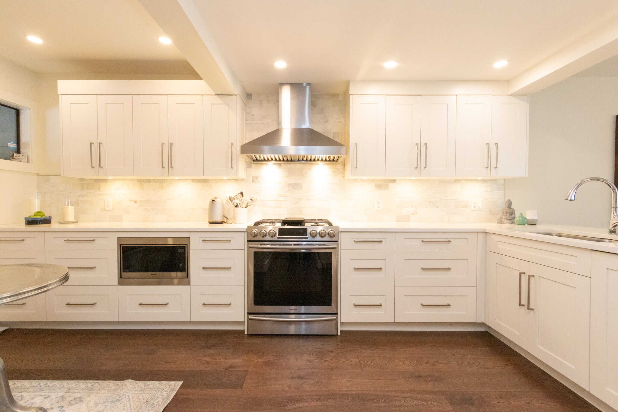 Modern West Vancouver Kitchen with White Cabinets and Stainless Steel Appliances Bright and spacious kitchen in West Vancouver featuring white cabinetry, stainless steel stove, and modern range hood, perfect for luxury home living.