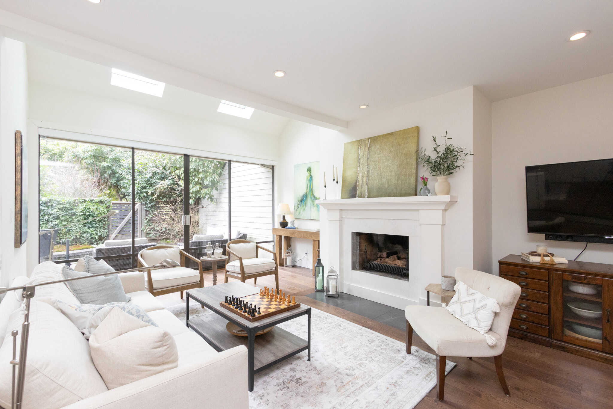 Modern West Vancouver living room with fireplace and natural light Bright West Vancouver living room featuring a cozy fireplace, large windows, and contemporary furniture, perfect for relaxing and entertaining in a luxurious home setting.