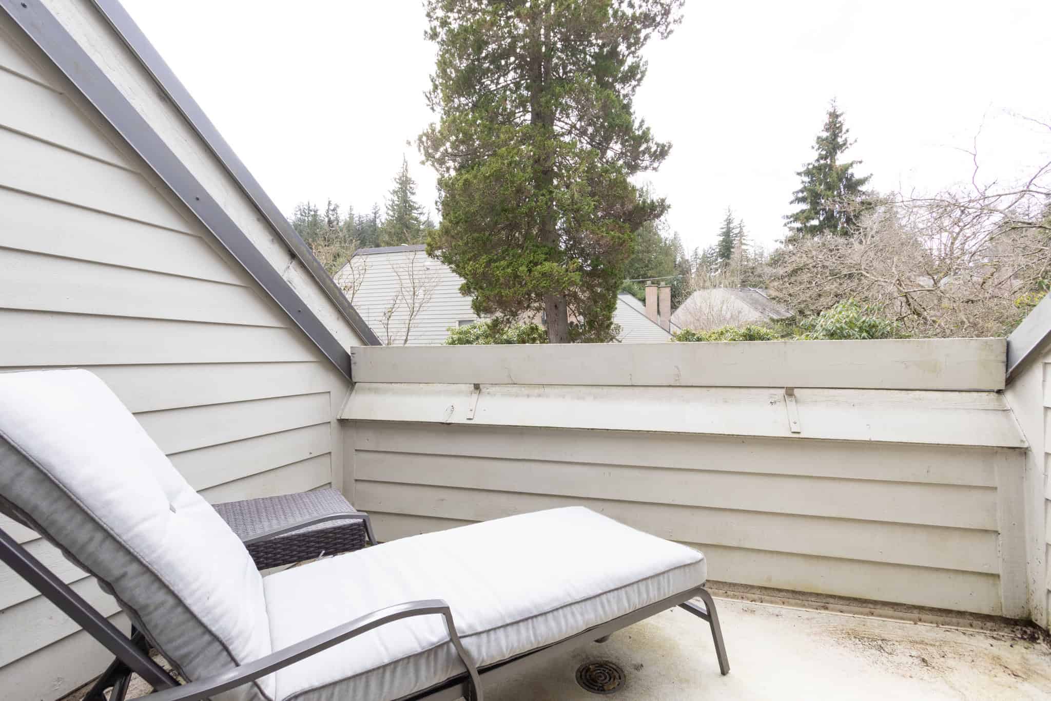 Ocean View Balcony – West Vancouver Cozy balcony with ocean view in West Vancouver, featuring outdoor lounge chair and privacy fencing, perfect for relaxing and enjoying scenic marine vistas.