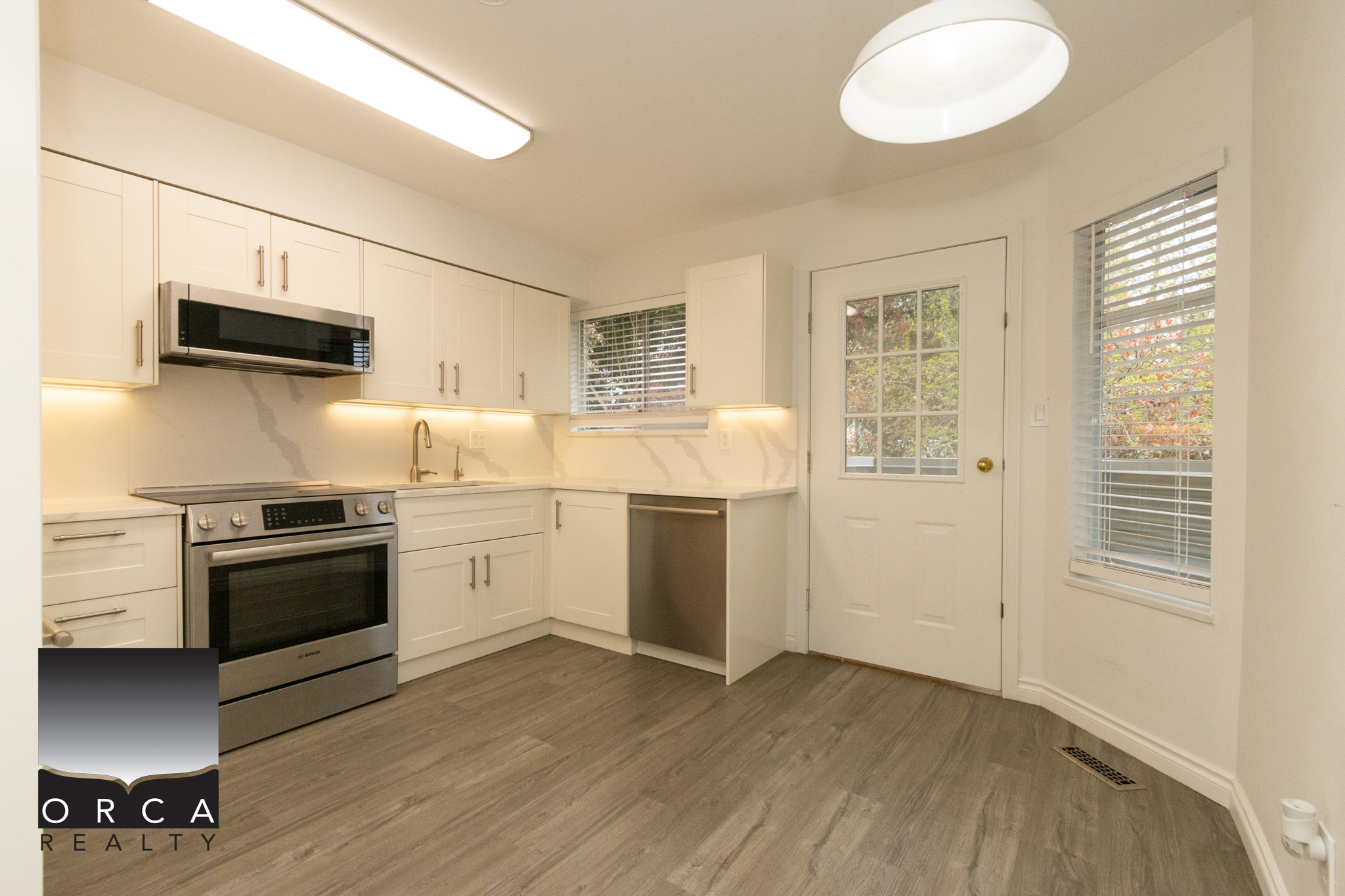 Spacious kitchen with white cabinets, stainless steel appliances, and natural light in Richmond property. Perfect for family living and entertaining.