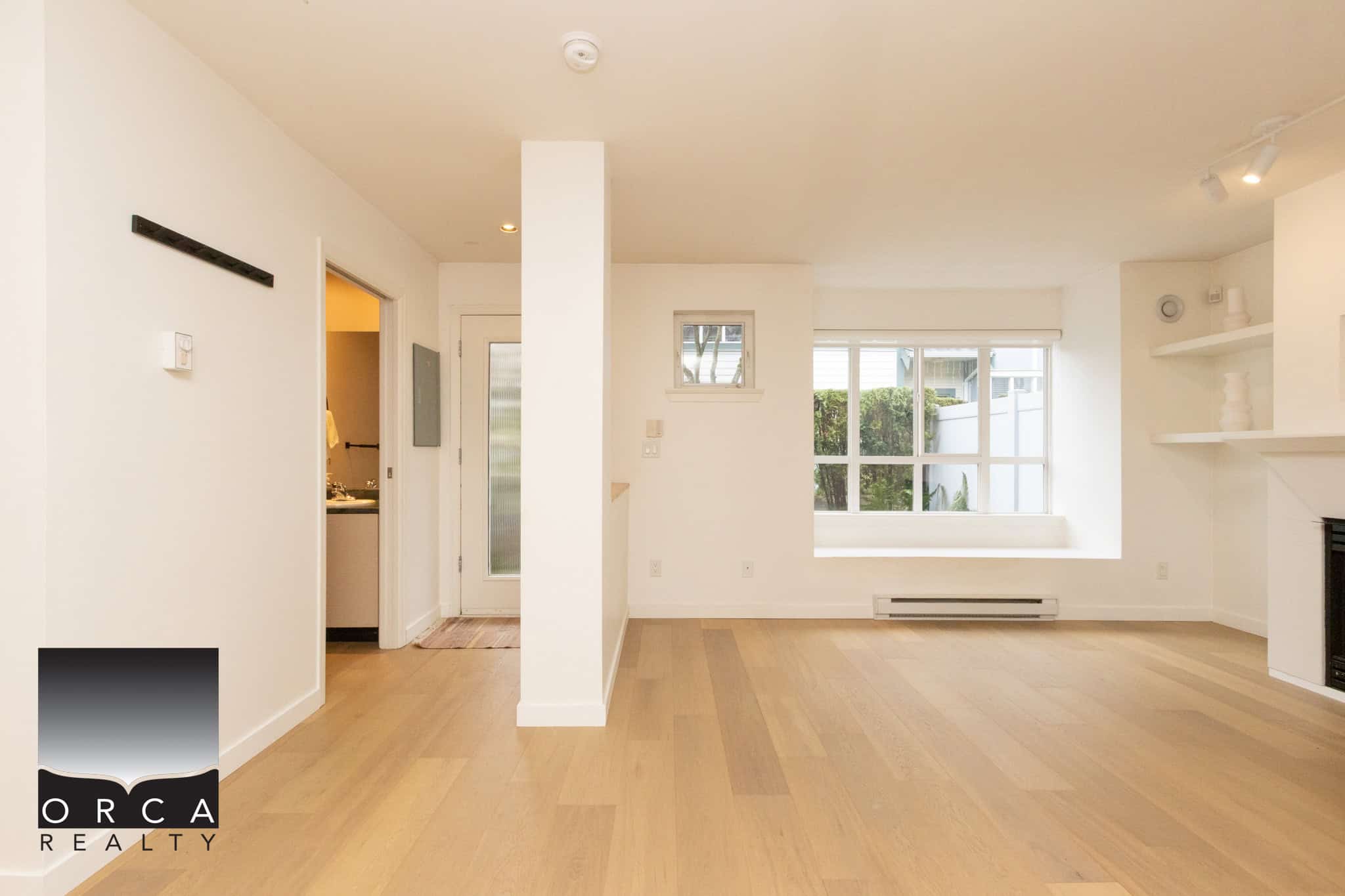 Bright and spacious living room with large windows and hardwood flooring in a Burnaby residence. Perfect for family gatherings and relaxing in a stylish, contemporary setting.