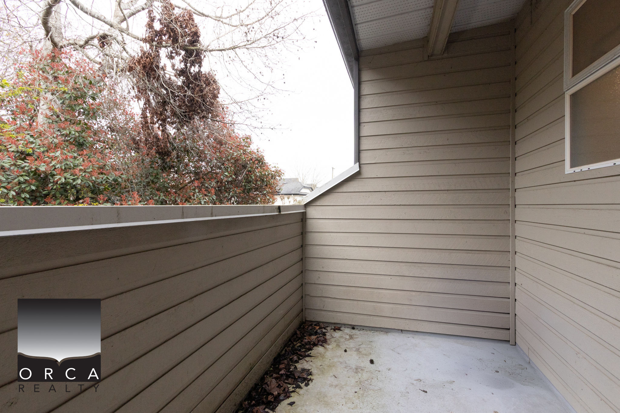 Spacious balcony with beige siding and railing, perfect for relaxing or outdoor dining in Richmond.