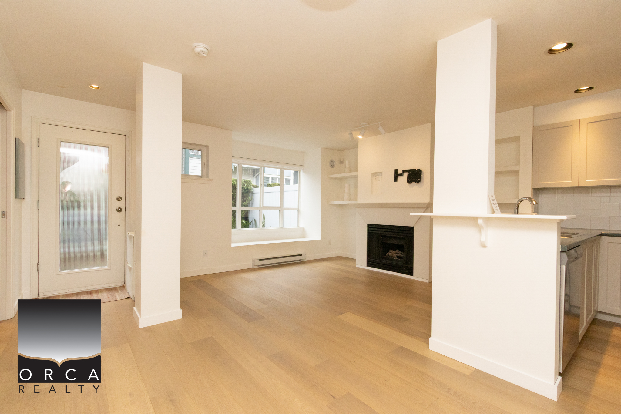 Bright and spacious living room with large windows and hardwood flooring in a Burnaby residence. Perfect for family gatherings and relaxing at home.
