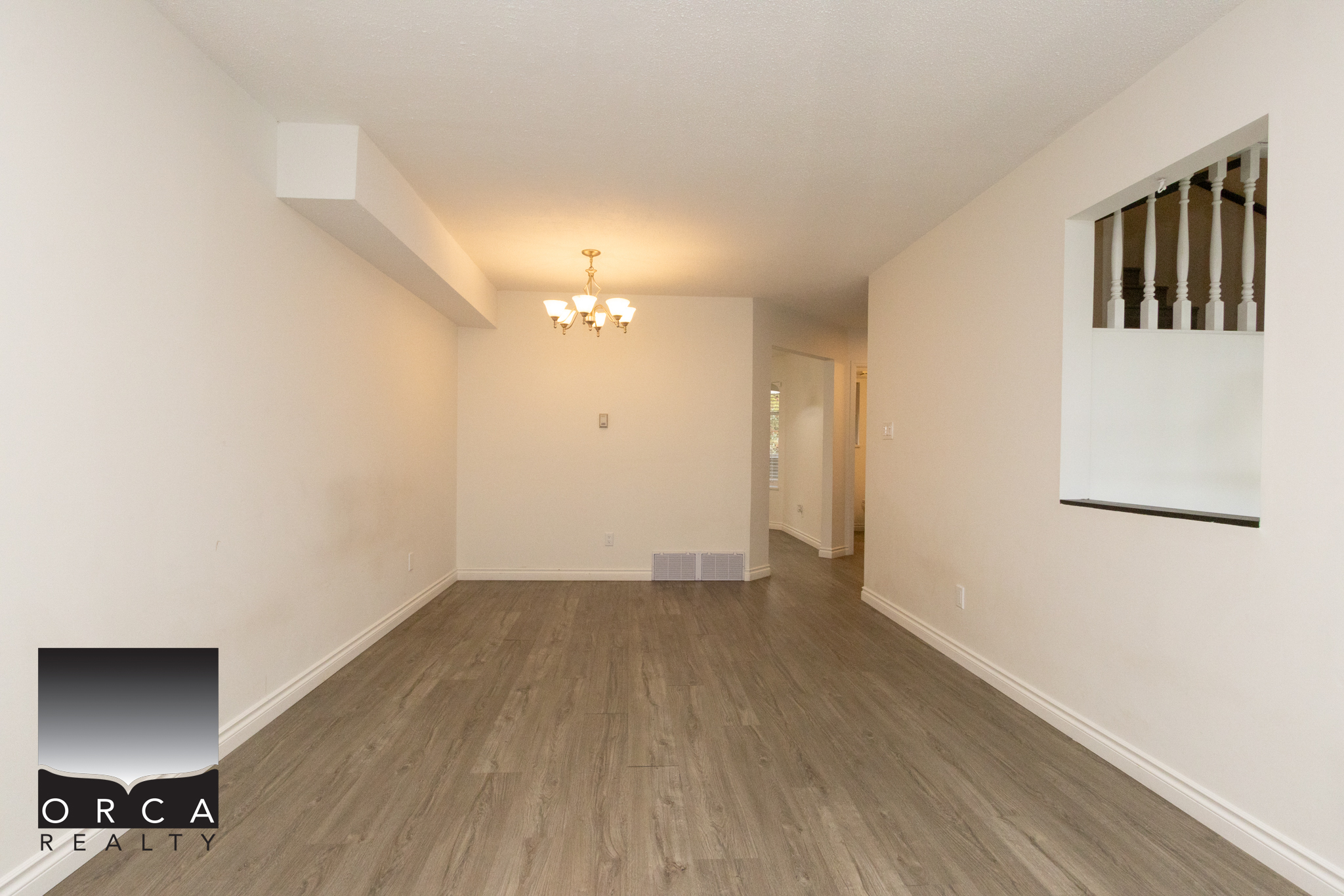 Spacious living room with neutral walls and hardwood flooring, perfect for family gatherings or relaxing. Located at 11-8751 Bennett Road, Richmond, this property offers comfort and convenience.