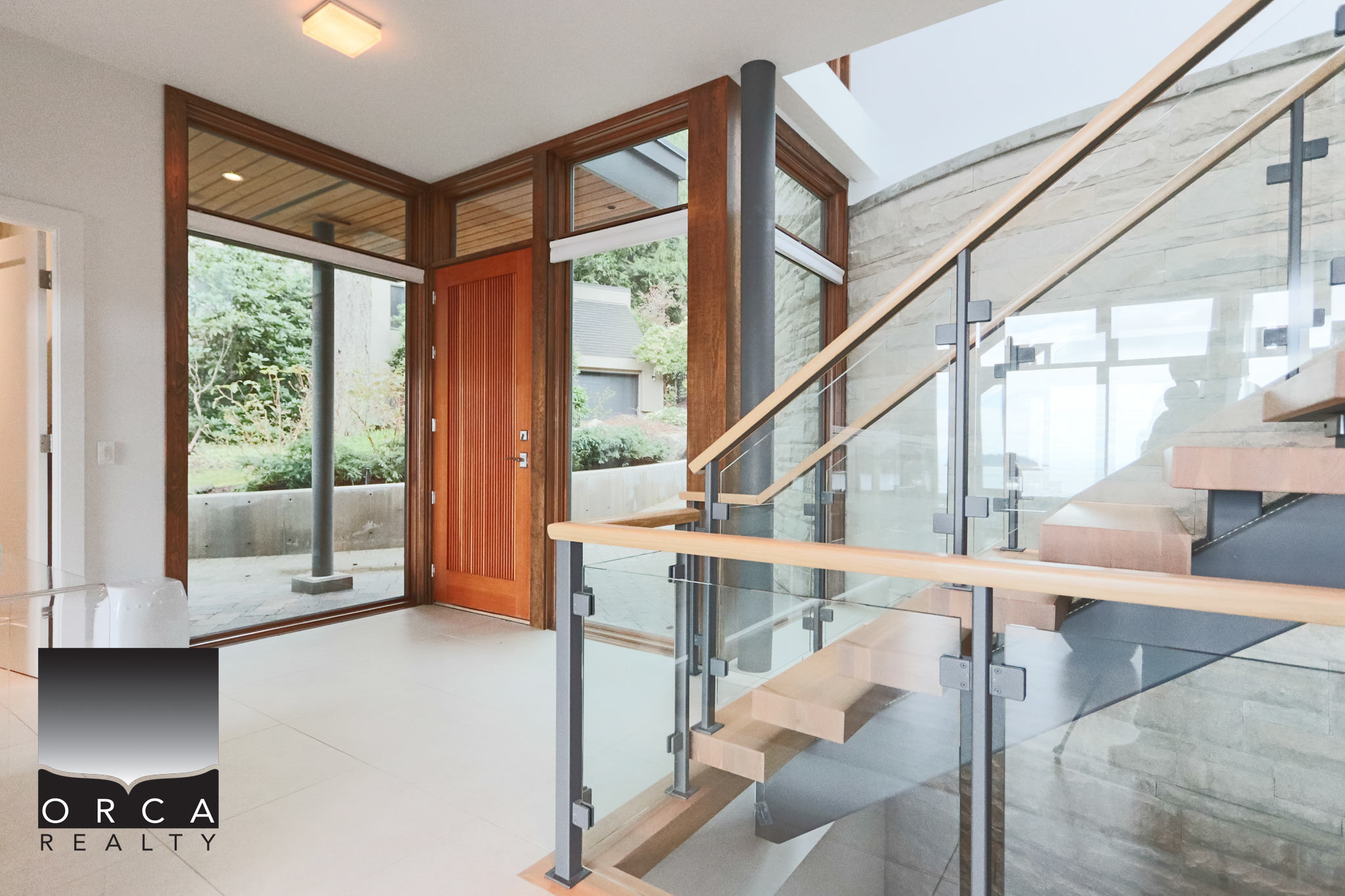 Modern West Vancouver Home Entrance Spacious entrance of a West Vancouver home with large glass doors and wooden accents, showcasing contemporary design and natural light.