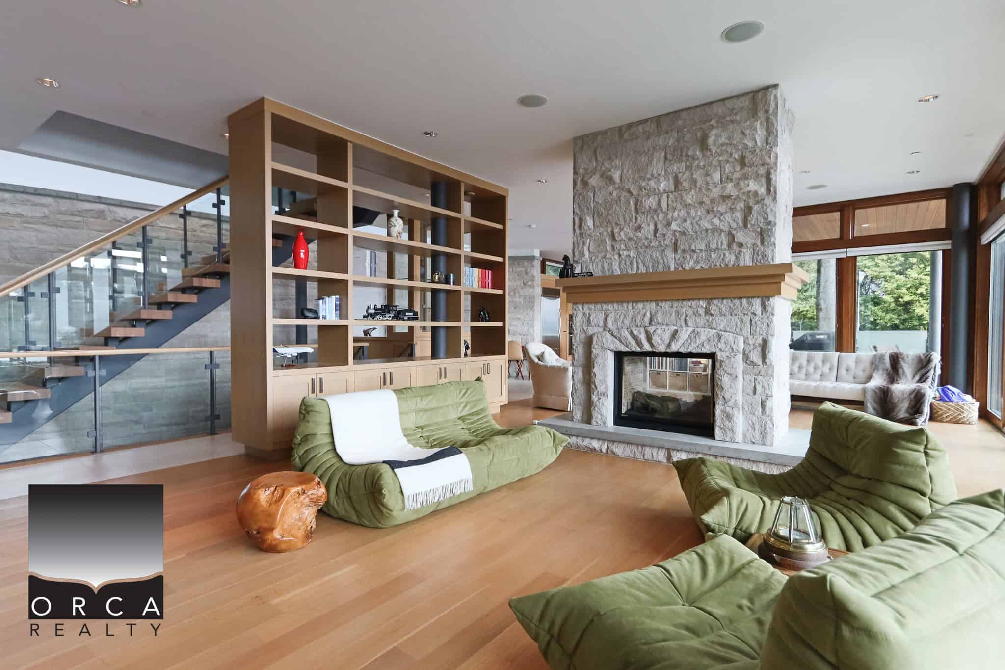 Modern West Vancouver Living Room Spacious living room in a West Vancouver home with a stone fireplace, large windows, and contemporary furniture, perfect for relaxing and entertaining.