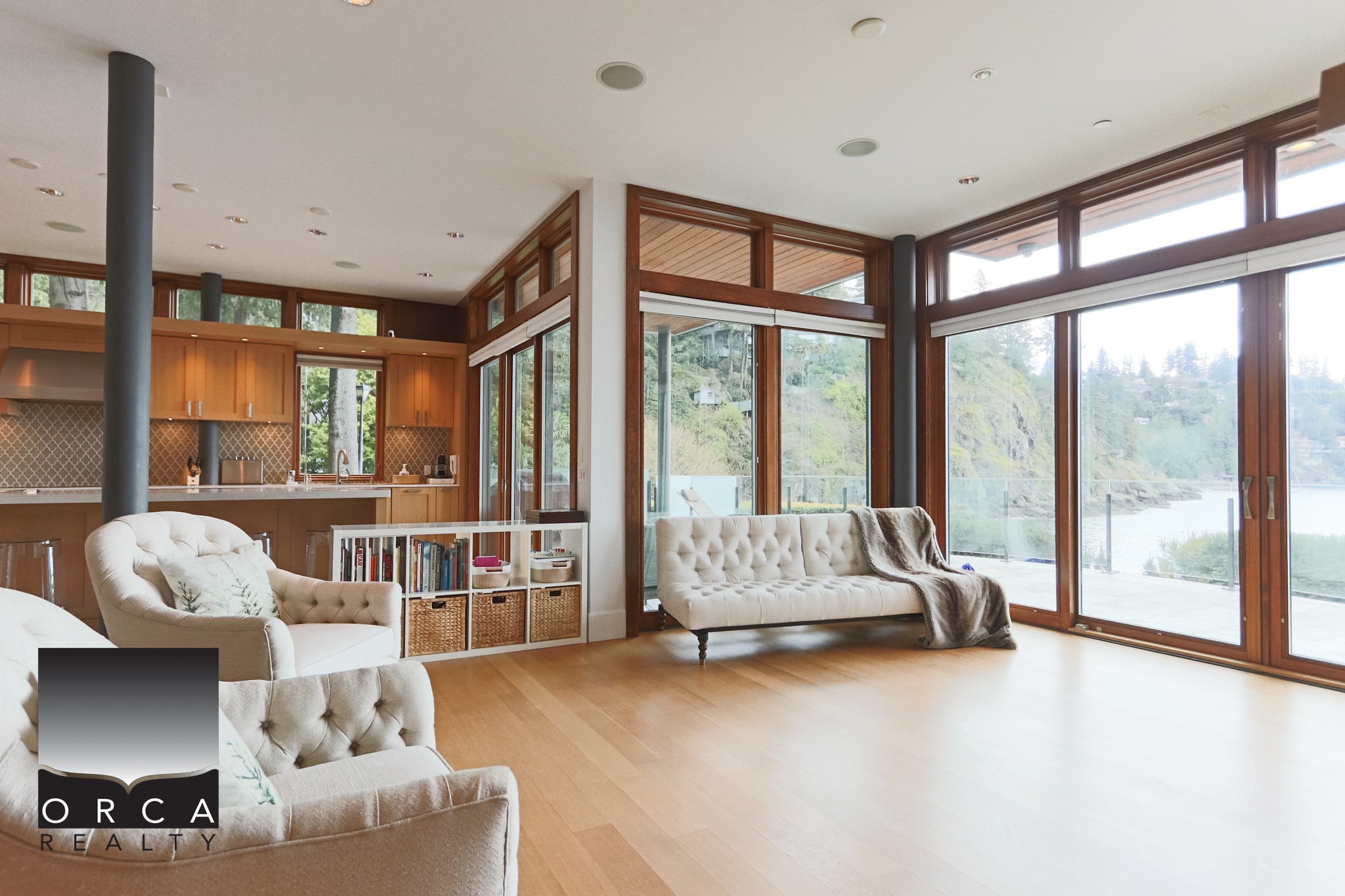 Modern West Vancouver Living Room with Floor-to-Ceiling Windows Spacious living room featuring large windows with scenic water views, hardwood floors, and contemporary furniture, located at 6780 Bachelor Bay Place, West Vancouver.