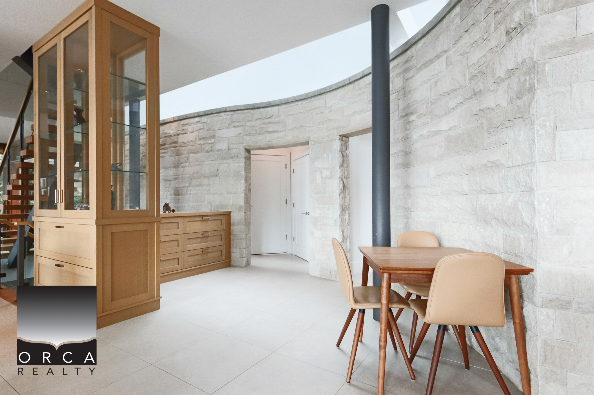 Modern West Vancouver Home Interior Interior view of a contemporary West Vancouver home with stone walls, wooden furniture, and a cozy dining area, showcasing elegant design and natural light.