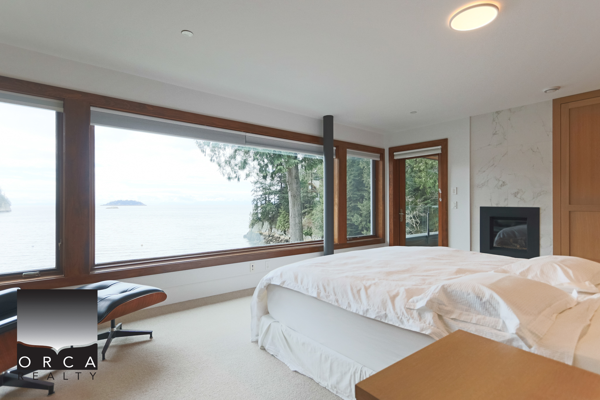 Luxury West Vancouver Waterfront Bedroom with Ocean View Bright bedroom featuring expansive windows overlooking the ocean in West Vancouver. Modern interior with cozy bedding, natural light, and scenic water views.