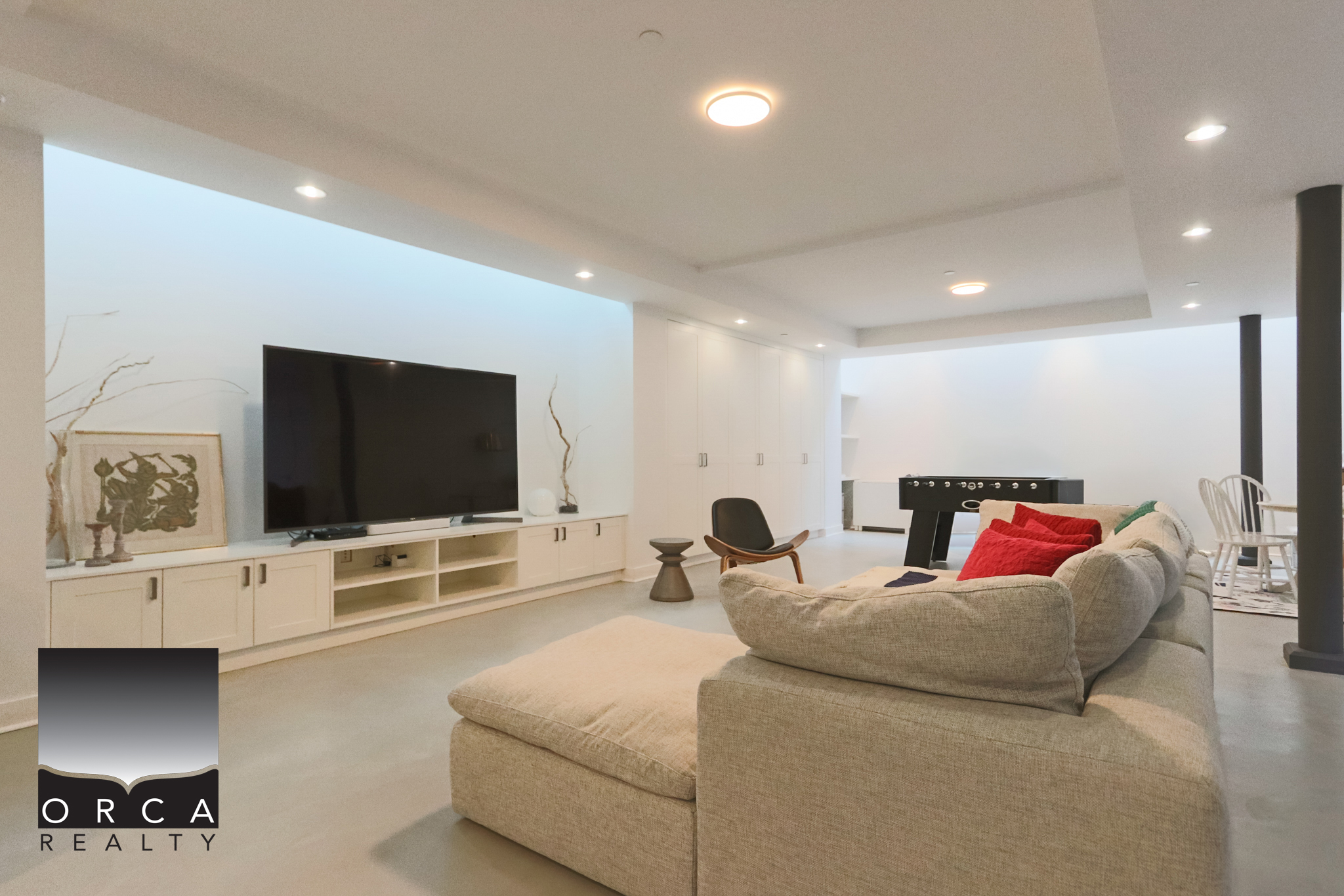 Modern West Vancouver living room with sleek design and minimalist decor. Spacious interior featuring a large flat-screen TV, comfortable sectional sofa, and contemporary furnishings, perfect for relaxing or entertaining.