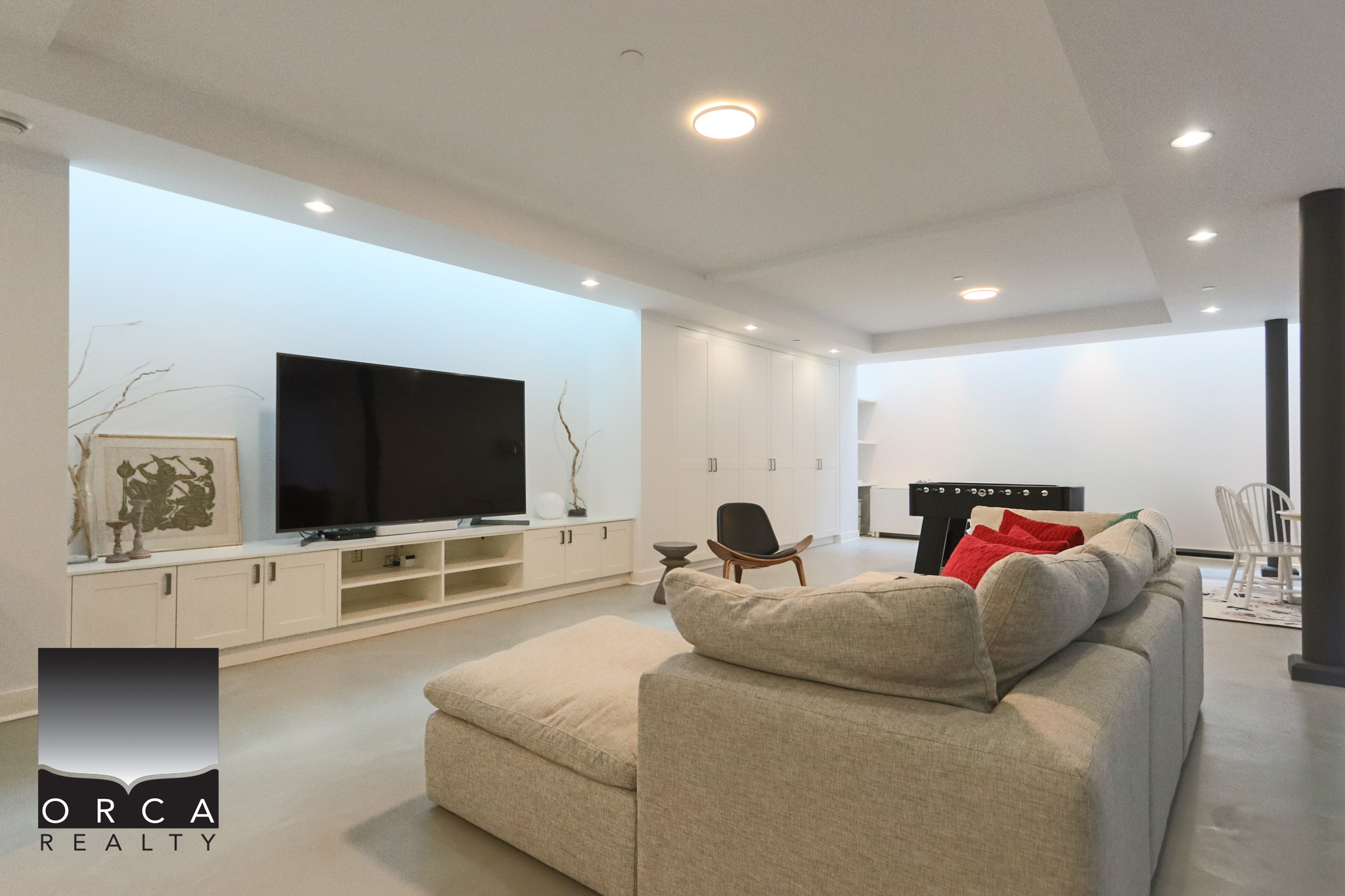 Modern West Vancouver Living Room Spacious living room with contemporary decor, featuring a large flat-screen TV, comfortable sectional sofa, and sleek white cabinetry, perfect for relaxing and entertaining.
