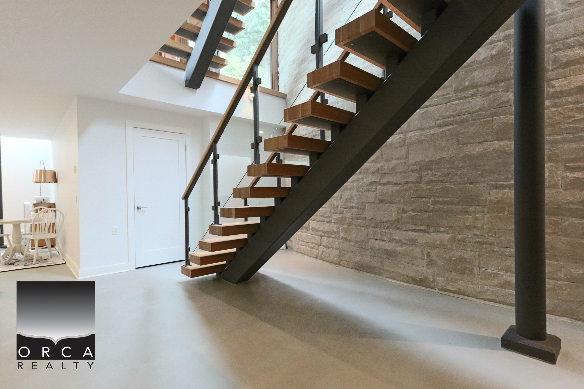 Modern Interior Staircase at 6780 Bachelor Bay Place Stylish wooden staircase with black metal supports in a contemporary West Vancouver home. Bright, airy space with natural light and minimalist decor.