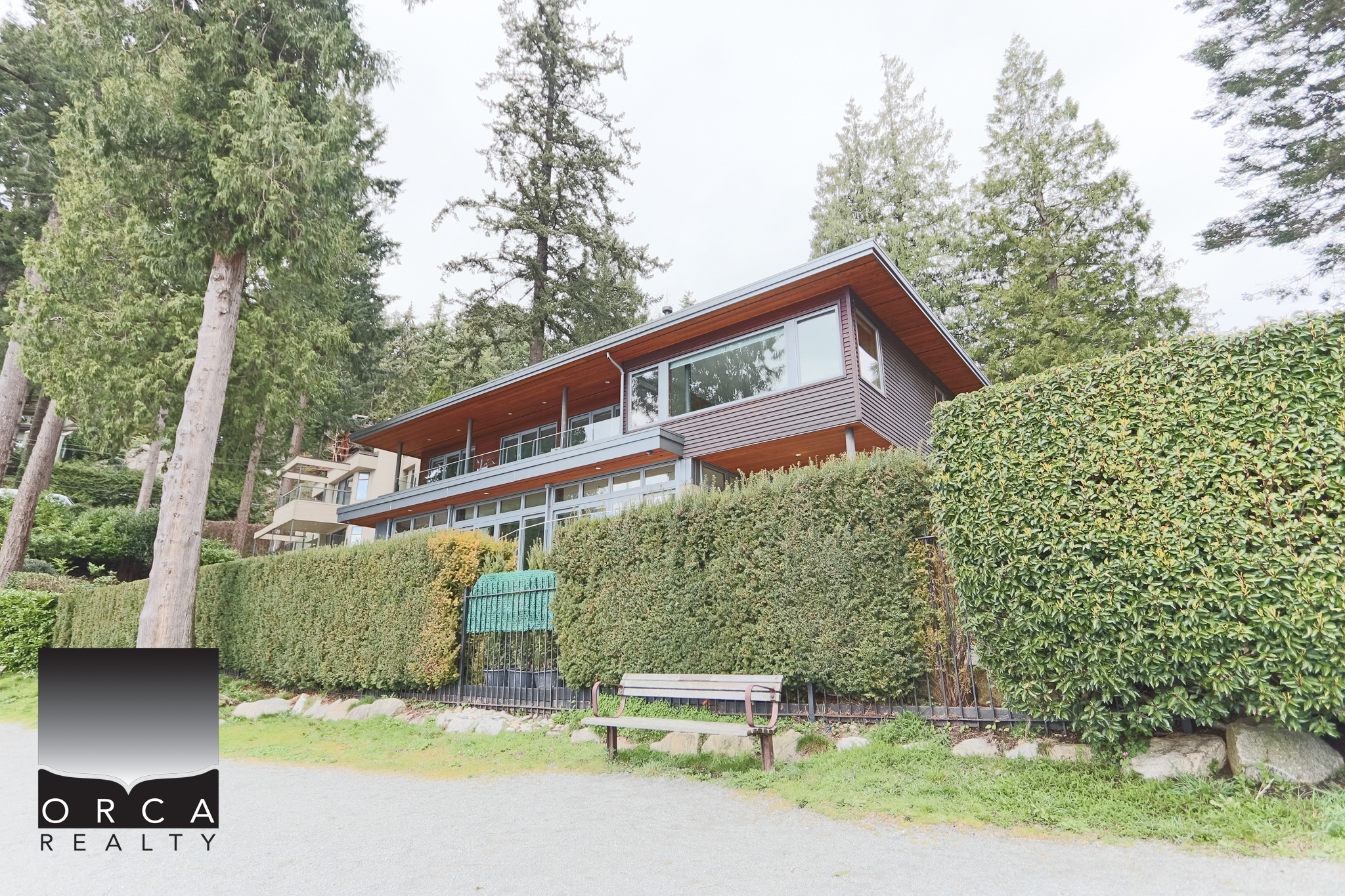 Modern West Vancouver Home with Lush Surroundings Spacious contemporary house located at 6780 Bachelor Bay Place, West Vancouver, featuring large windows, a balcony, and scenic views of nature.