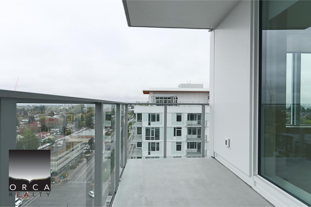 Balcony overlooking Vancouver cityscape with glass railing and modern building architecture. Perfect for enjoying outdoor space in a contemporary urban home.