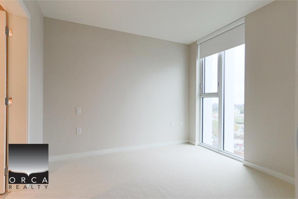 Bright, spacious empty room with large floor-to-ceiling window, natural light, neutral walls, ideal for home staging or real estate listings in Victoria, BC.