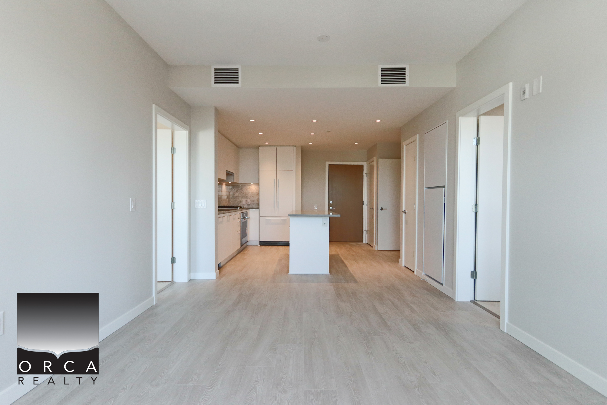 Modern open-concept kitchen and living space Bright, modern open-concept kitchen and living area with neutral tones, hardwood flooring, and ample natural light, ideal for contemporary home living in Vancouver.