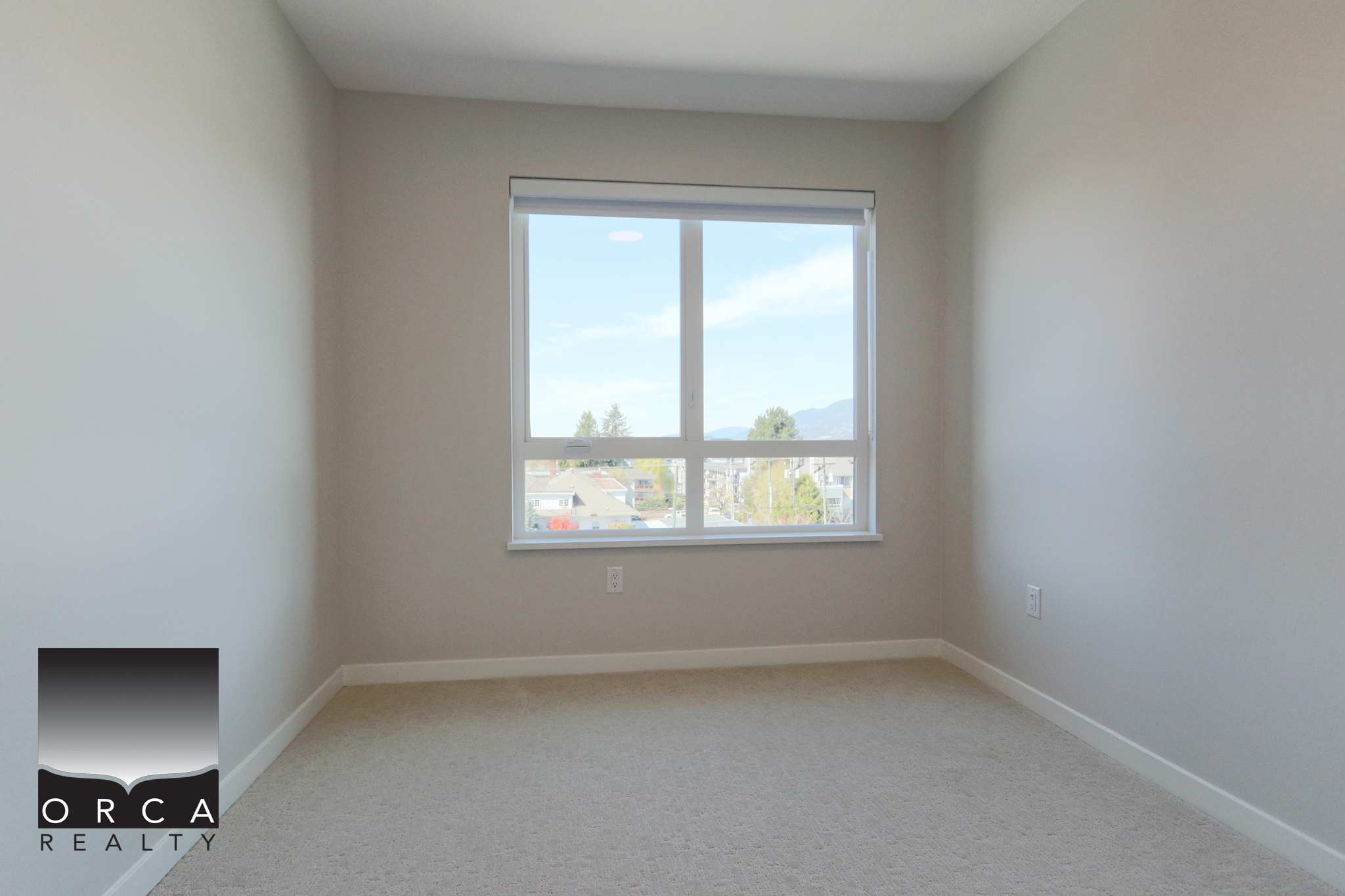 Modern empty bedroom with large window and natural light, ideal for home staging or real estate listing. Bright, spacious bedroom with a large window offering scenic views, perfect for showcasing property features in real estate listings.