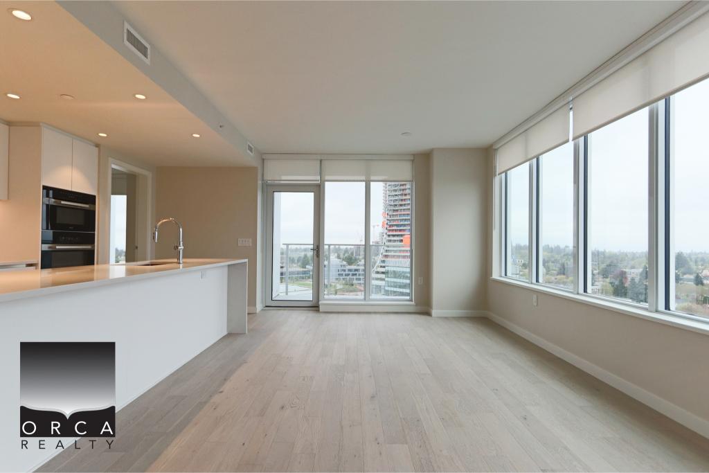 Spacious, bright living room in a high-rise condo with large windows and cityscape views, perfect for urban living and entertaining.