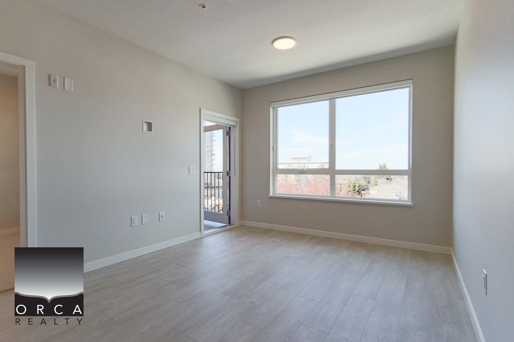 Modern Bright Living Room with Large Window Bright and spacious living room featuring a large window with city views, neutral wall colours, and light wood flooring, ideal for comfortable living and interior design.