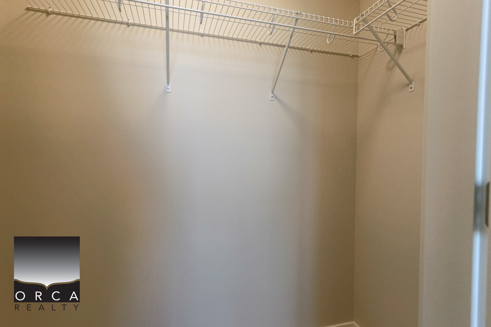 Spacious Walk-In Closet with Shelving Walk-in closet with built-in shelves and hanging rods, ideal for organized storage in a modern home.