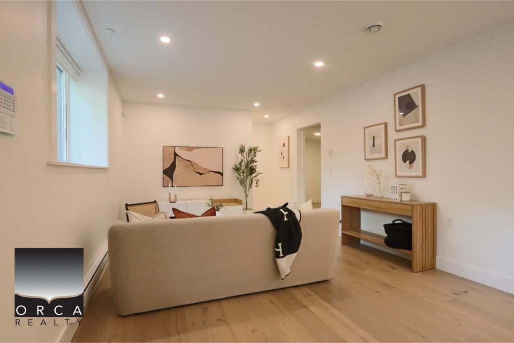 Modern living room featuring a beige sofa, contemporary artwork, and natural light.