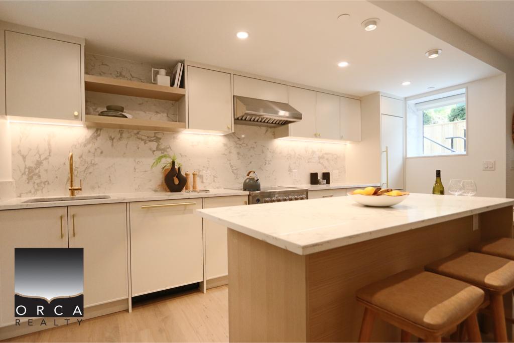 Spacious modern kitchen featuring white cabinets, marble backsplash, and a large island with seating, perfect for family gatherings and entertaining. Bright, airy space with natural light from a windo.