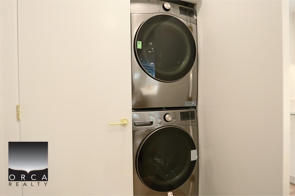 Stacked front-loading washing machine and dryer in a compact laundry space.