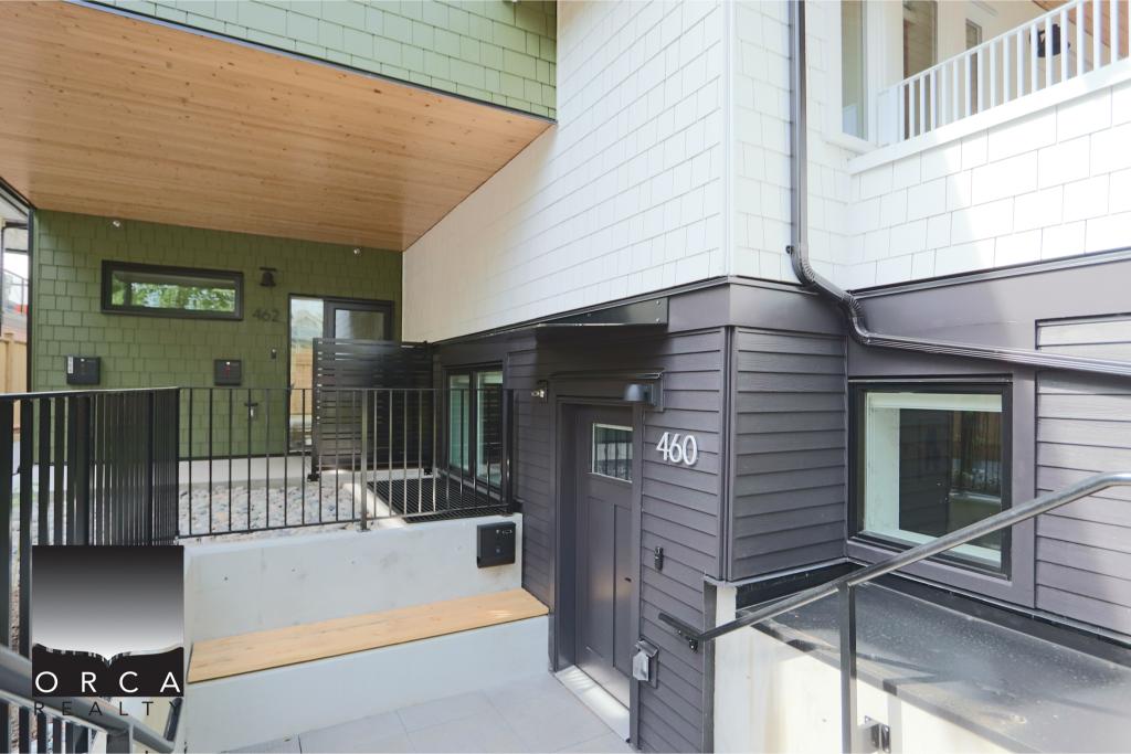 Modern townhouse entrance featuring sleek black and green exterior siding, a small front porch, and a secure black metal gate, located at 460.