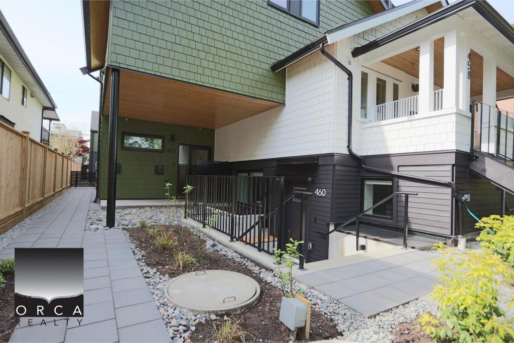 Spacious modern house with green and white exterior, featuring a welcoming front porch and landscaped yard, located in a desirable neighborhood.