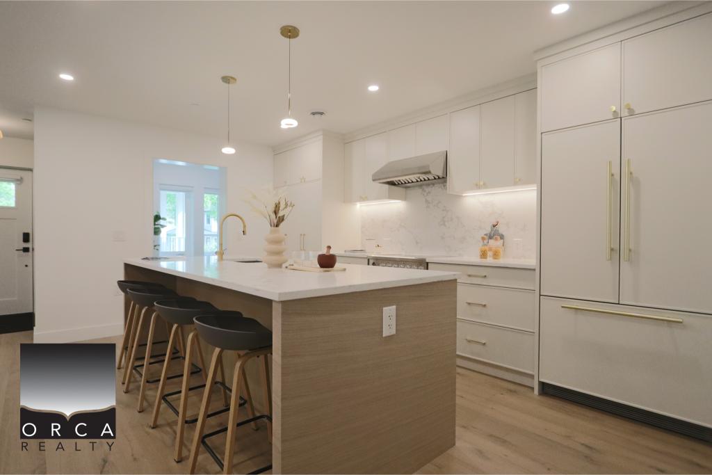 Contemporary white kitchen featuring an island with bar stools, sleek cabinetry, and modern appliances, ideal for homebuyers and real estate listings.