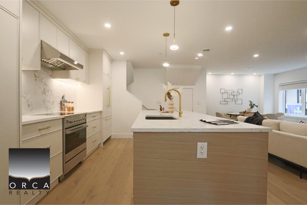Bright and modern kitchen with white cabinetry, marble backsplash, and central island featuring a gold faucet, ideal for contemporary Vancouver-area homes.