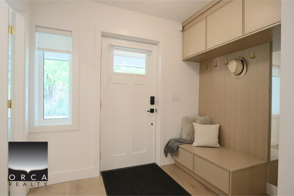 Bright and welcoming entryway featuring built-in storage, a cozy seating nook with cushions, and a clean, minimalist design perfect for a Vancouver-area home.